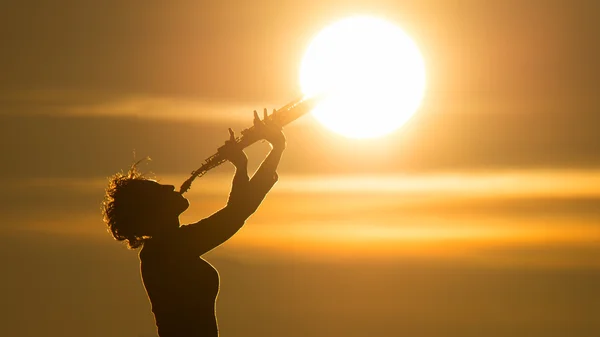 Woman playing a saxophone at the sun — Stock Photo, Image