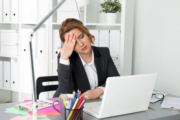 Portrait of tired businesswoman sitting at her office Stock Picture