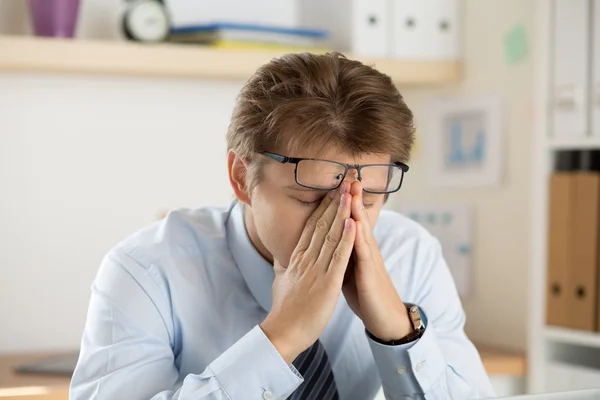 Employé de bureau fatigué touchant son pont de nez pour donner du repos à — Photo