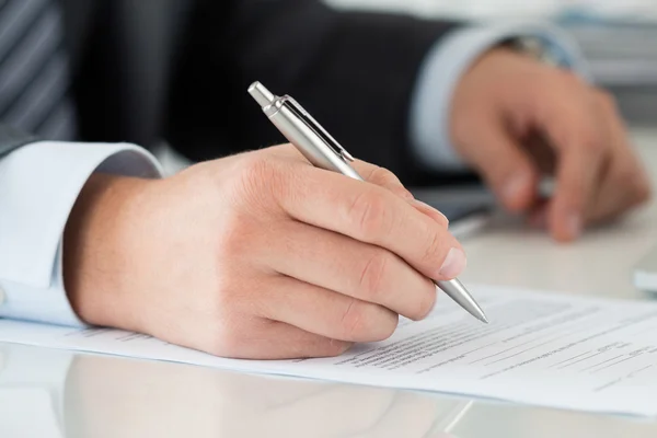 Close-up of businessman hands signing documents