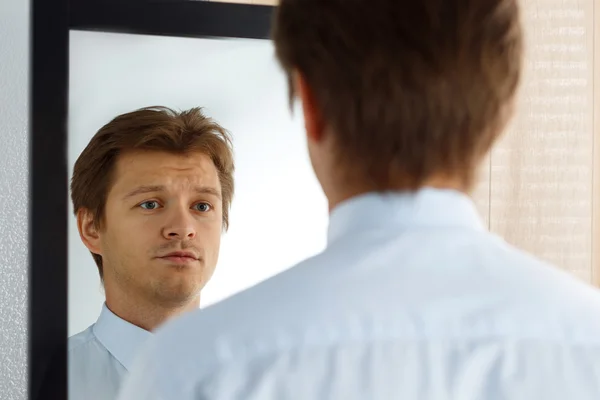 Portrait of unsure young businessman with unhappy face — Stock Photo, Image