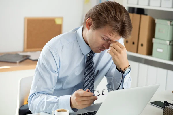 Müder Büroangestellter, der seinen Nasenrücken berührt, um Ruhe zu geben — Stockfoto