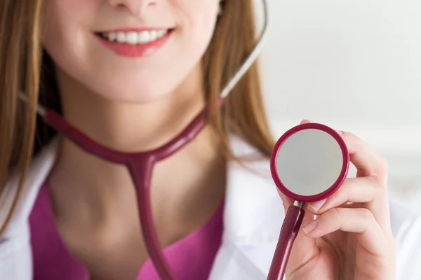 Hermosa sonriente médico femenino sosteniendo estetoscopio — Foto de Stock