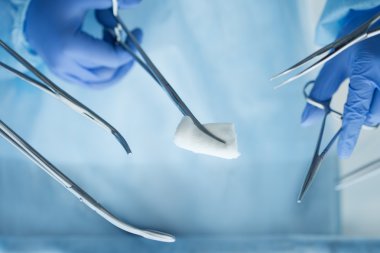 Cerrahi aletler tutan doktor ellerinin yakından görünümü