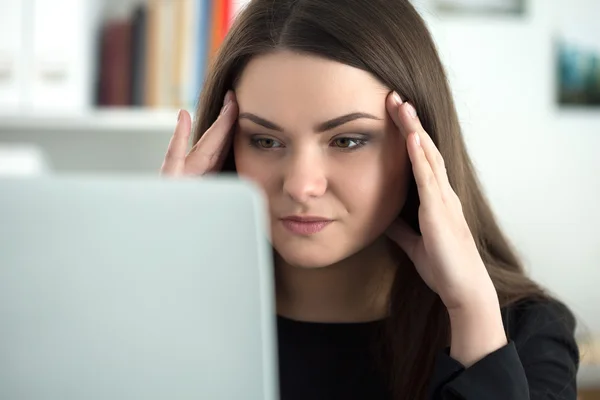 Müde Mitarbeiterin am Arbeitsplatz im Büro berührt ihren Kopf — Stockfoto