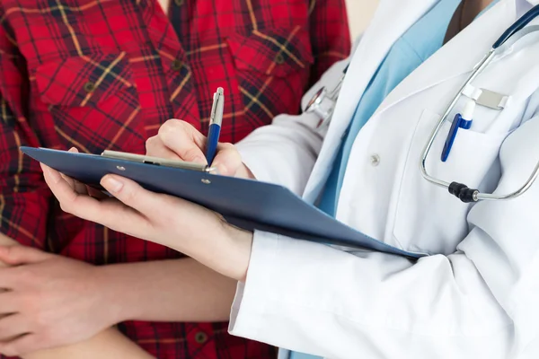 Médico manos llenando historia del paciente — Foto de Stock