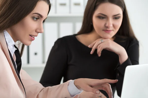 Due donne sedute in ufficio a guardare il monitor del portatile — Foto Stock