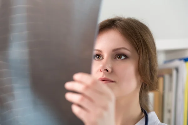 Jeune femme médecin qui regarde la radiographie pulmonaire — Photo