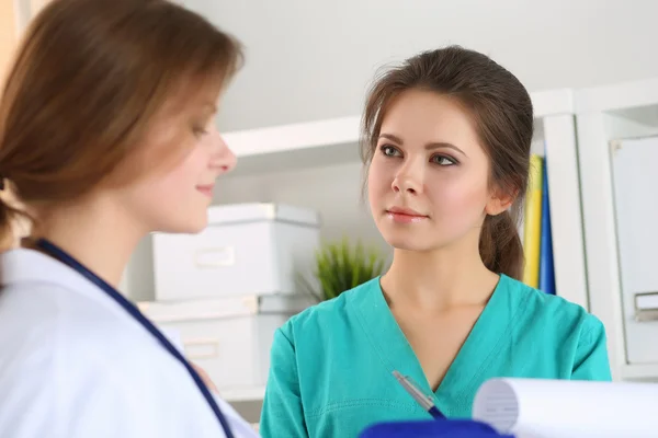 Two beautiful female medicine doctors working at their office — Stock Photo, Image