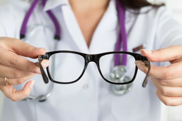 Női szemorvos orvos kezét, amely szemüveget. Jó látás — Stock Fotó