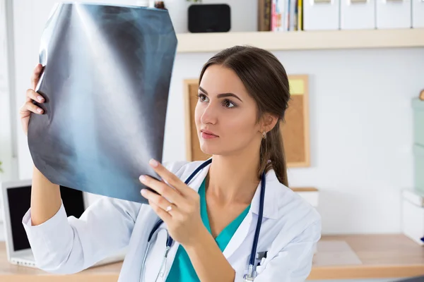 Young female medical doctor or intern looking at lungs x-ray ima — Stock Photo, Image