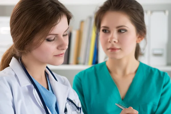 Deux tristes médecins inquiets debout à leur bureau — Photo