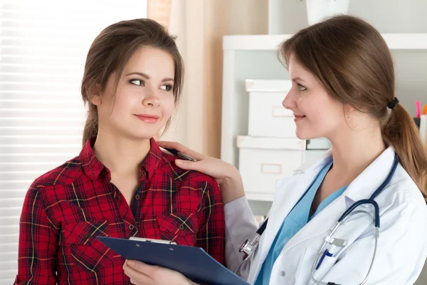 Friendly female doctor touching patient shoulder telling good ne — Stock Photo, Image