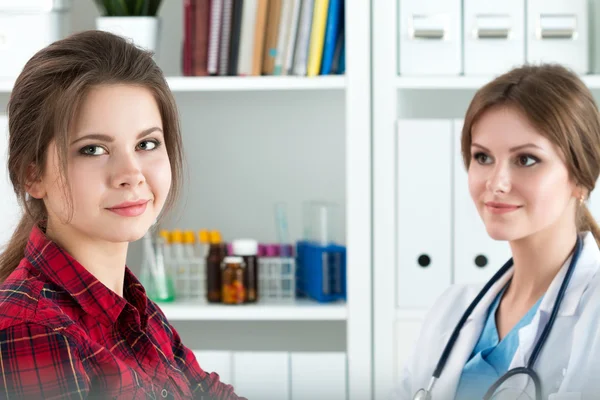 Mujer sonriente sentada en el consultorio del médico de medicina — Foto de Stock