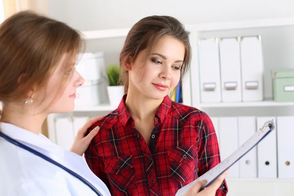 Friendly female doctor touching patient shoulder for encourageme Stock Picture