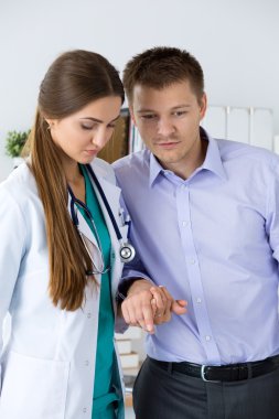 Kadın tıp doktor hastasını operati sonra yürümeye yardımcı
