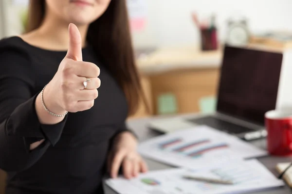 Kobieta biznesu pokazuje kciuka w górę siedzi w jej biurze — Zdjęcie stockowe