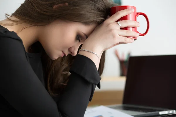 Müde Mitarbeiterin am Arbeitsplatz im Büro berührt ihren Kopf — Stockfoto