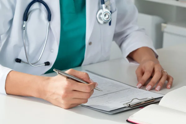 Medicina feminina médicos mãos preenchendo paciente forma médica — Fotografia de Stock