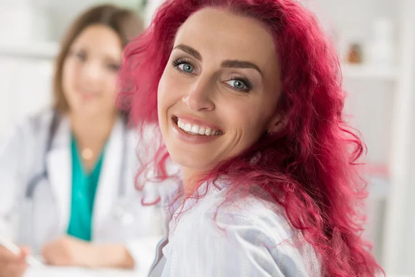 Smiling happy female patient sitting at medicine doctor office — Stock Photo, Image