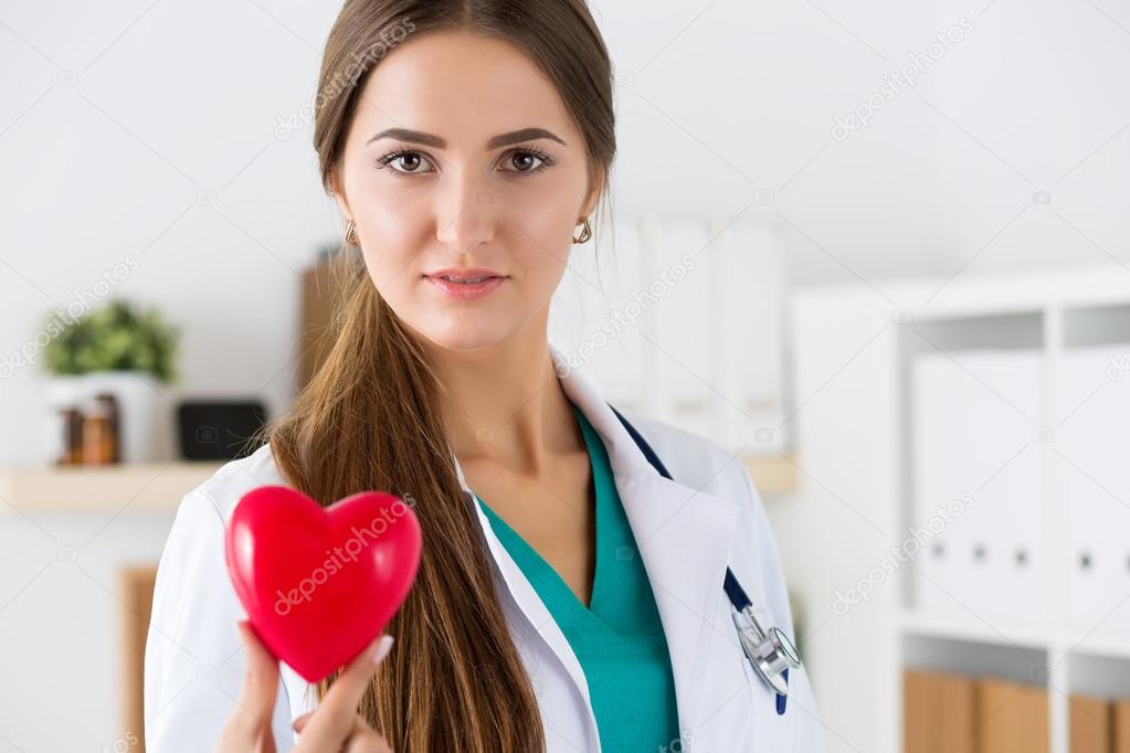 Female medicine doctor hold in hands red toy heart