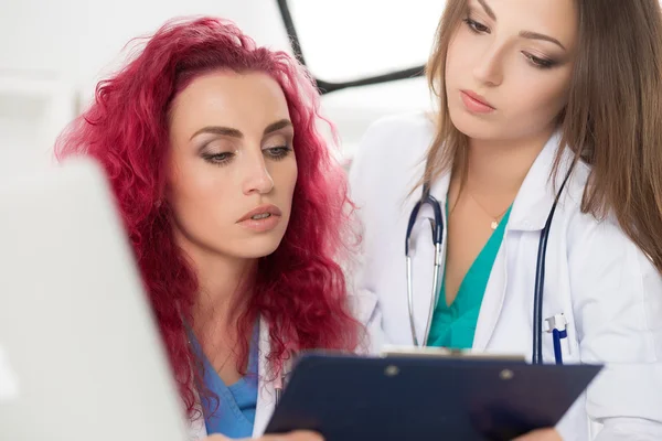 Two female doctors looking at patient information form — Stock Photo, Image