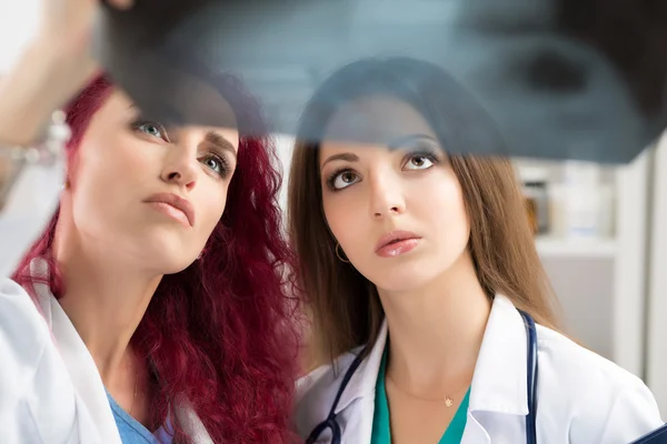 Два врача смотрят на рентгеновские снимки — стоковое фото