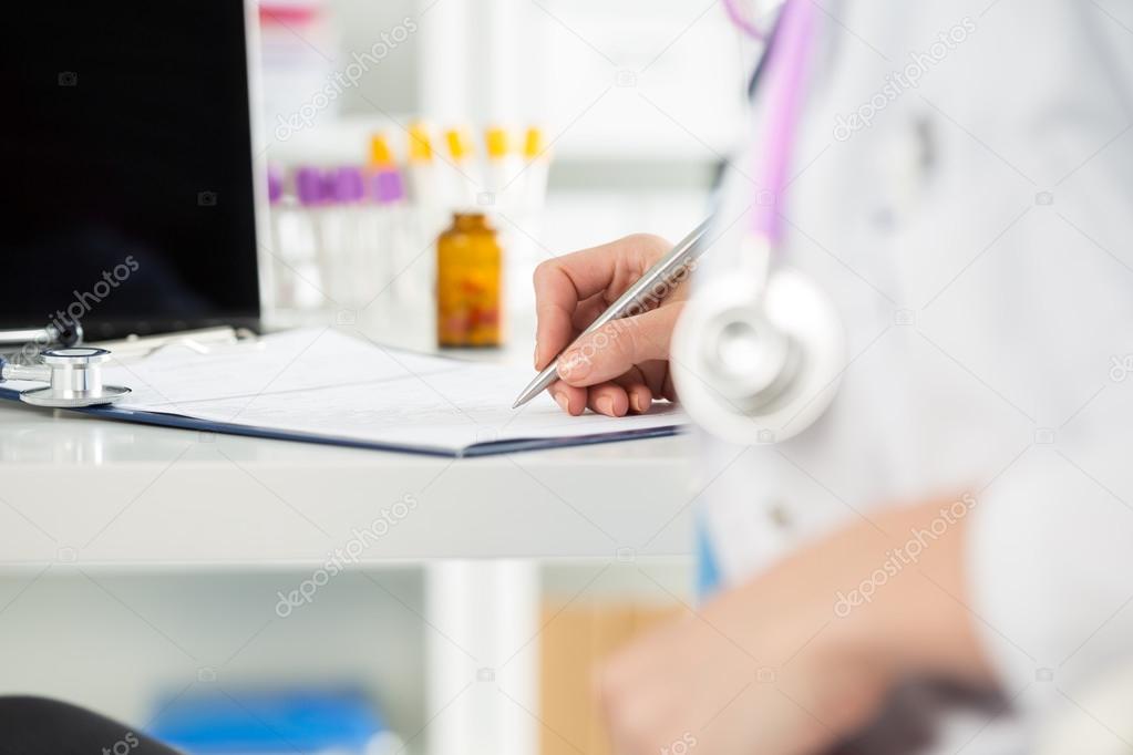 Close up view of female medicine doctors hands filling patient m