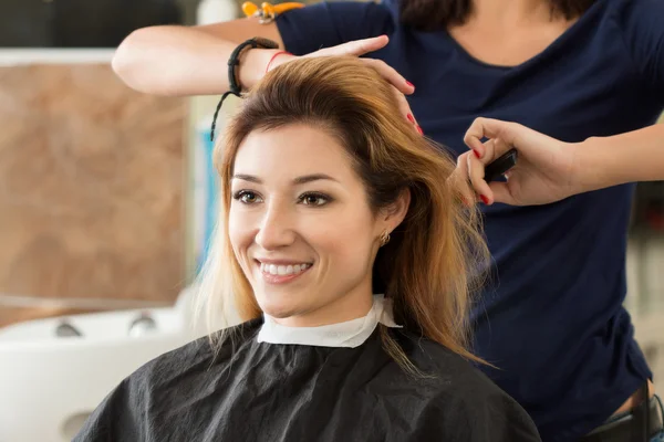 Nainen kampaaja ja asiakas päättää, mitä hiustenleikkuu tehdä — kuvapankkivalokuva