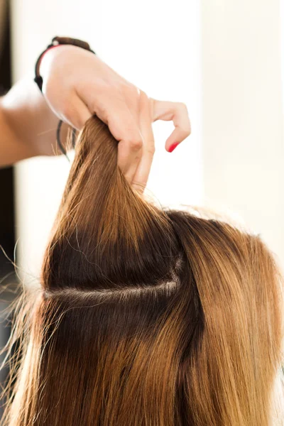 Vista de cerca de peluquería mano sosteniendo hebra de cabello — Foto de Stock