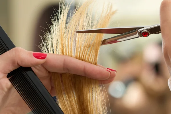 Крупный план женских рук парикмахера, стригущих волосы — стоковое фото