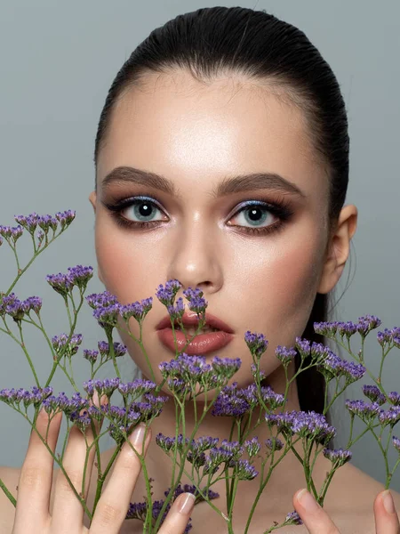 Porträtt av ung vacker kvinna med blommor — Stockfoto