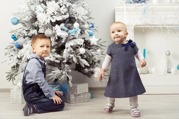 Two children (brother and sister) near christmas tree — Stock Photo, Image