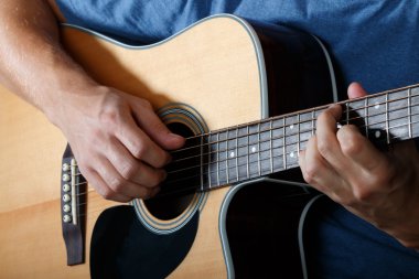 Man performing song on acoustic guitar clipart
