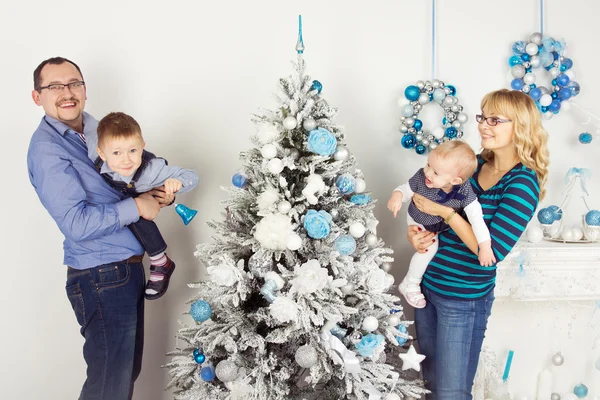 Happy family of four persons decorating christmas tree — Stock Photo, Image