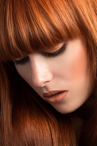 Beautiful red haired girl looking down portrait