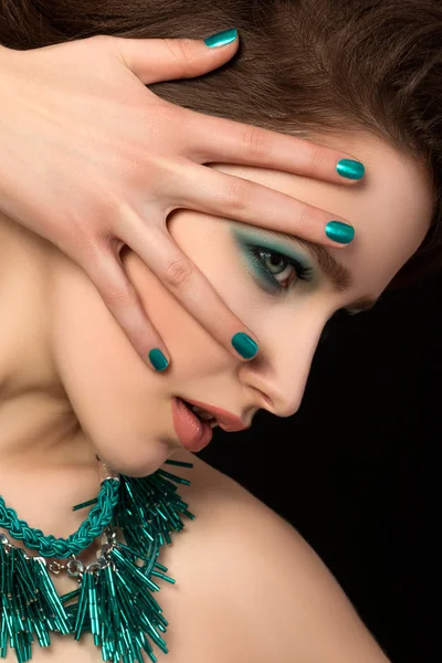 Retrato de una hermosa mujer joven con uñas azules y maquillaje de ojos — Foto de Stock