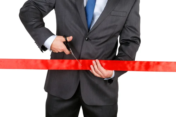 Businessman in suit cutting red ribbon with pair of scissors iso — Stock Photo, Image