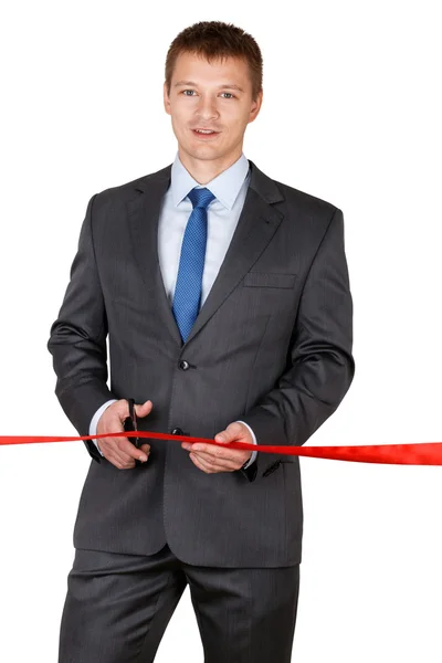 Businessman in suit cutting red ribbon with pair of scissors iso — Stock Photo, Image