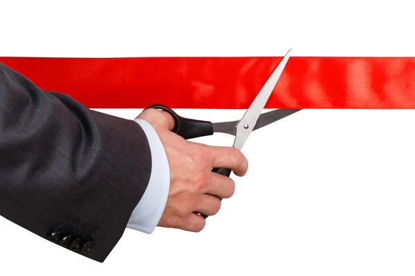 Businessman in suit cutting red ribbon with pair of scissors iso — Stock Photo, Image