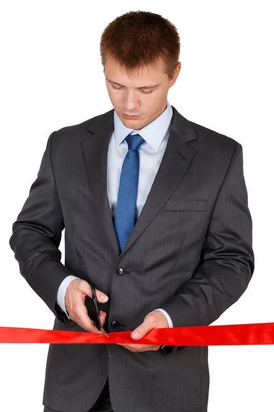 Businessman in suit cutting red ribbon with pair of scissors iso — Stock Photo, Image