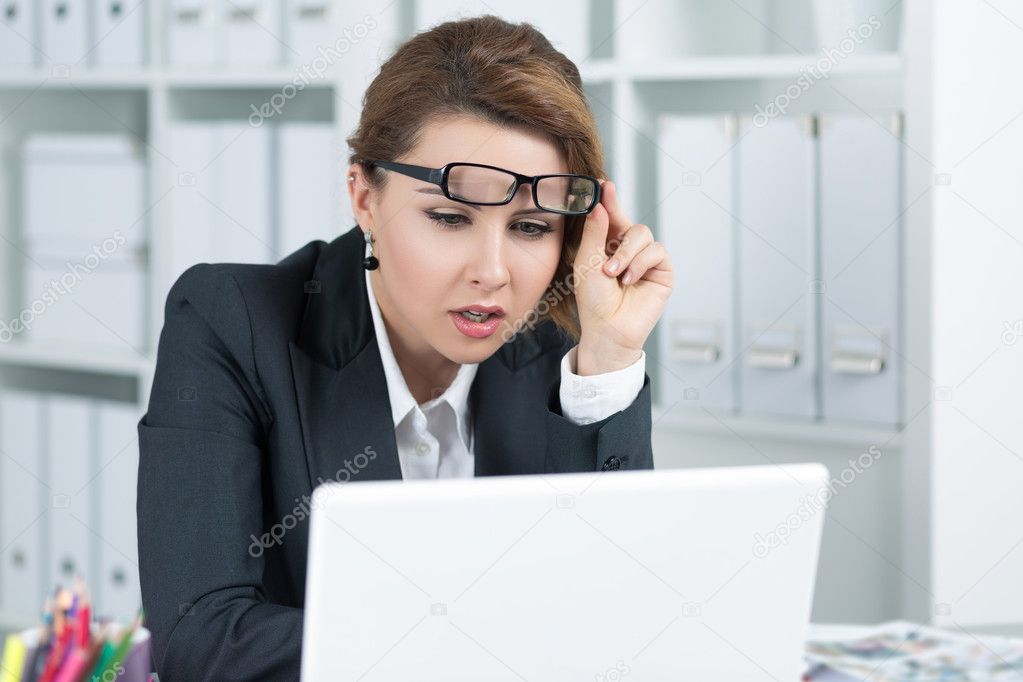 Young business woman looking intently at laptop 