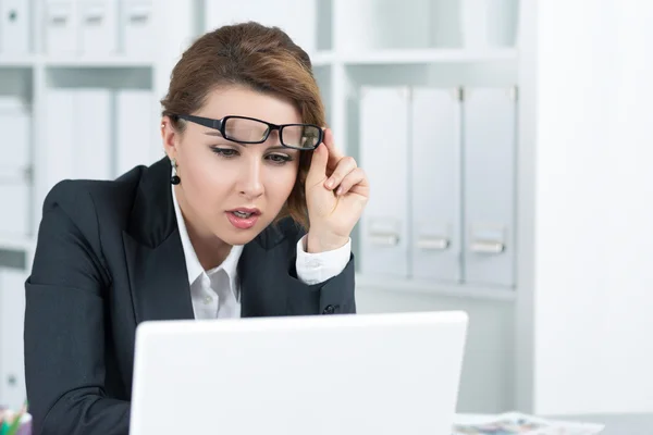 Mujer de negocios joven mirando atentamente a la computadora portátil — Foto de Stock