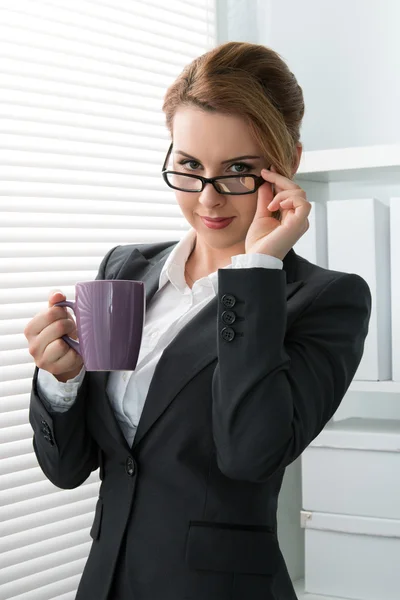 Speelse jonge zakenvrouw opstijgen haar bril — Stockfoto