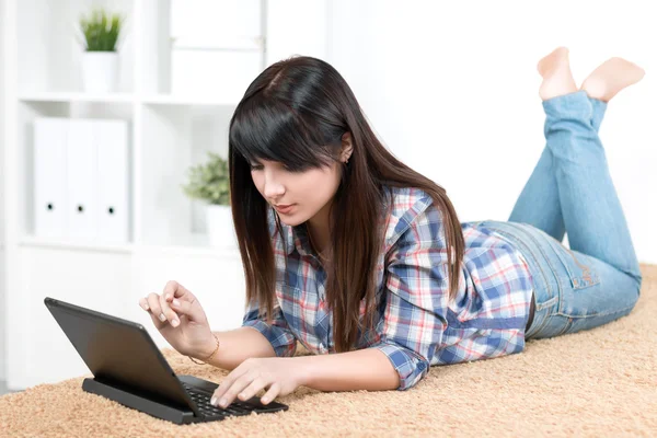 Tiener meisje studeren aan huis liggend op de Bank — Stockfoto