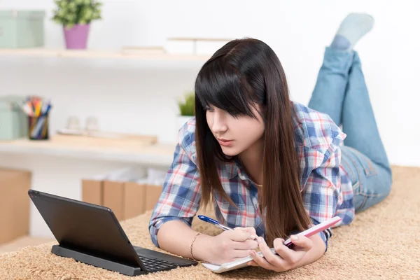 Adolescente chica estudiando en casa acostado en el sofá — Foto de Stock