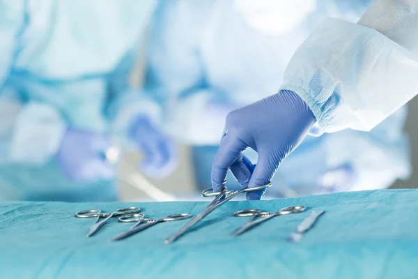 Close-up of scrub nurse taking medical instruments — Stock Photo, Image