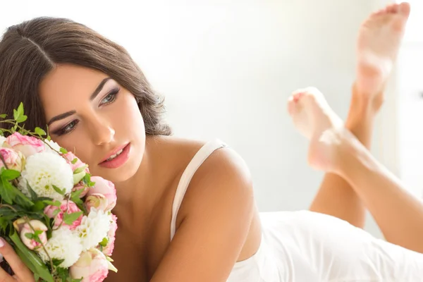 Bella sposa in lingerie bianca con bouquet nuziale — Foto Stock