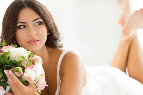 Bella sposa in lingerie bianca con bouquet nuziale — Foto Stock