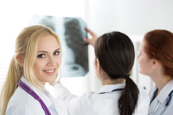 Portrait of smiling female medicine doctor with two colleagues — Stock Photo, Image